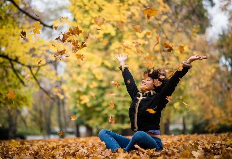 Woman in fall with arms up