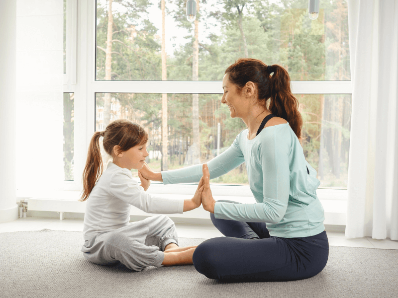 mother doing yoga with daughter